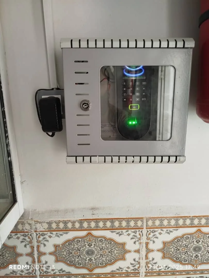 جهاز بصمة مثبت داخل صندوق معدني بواجهة شفافة